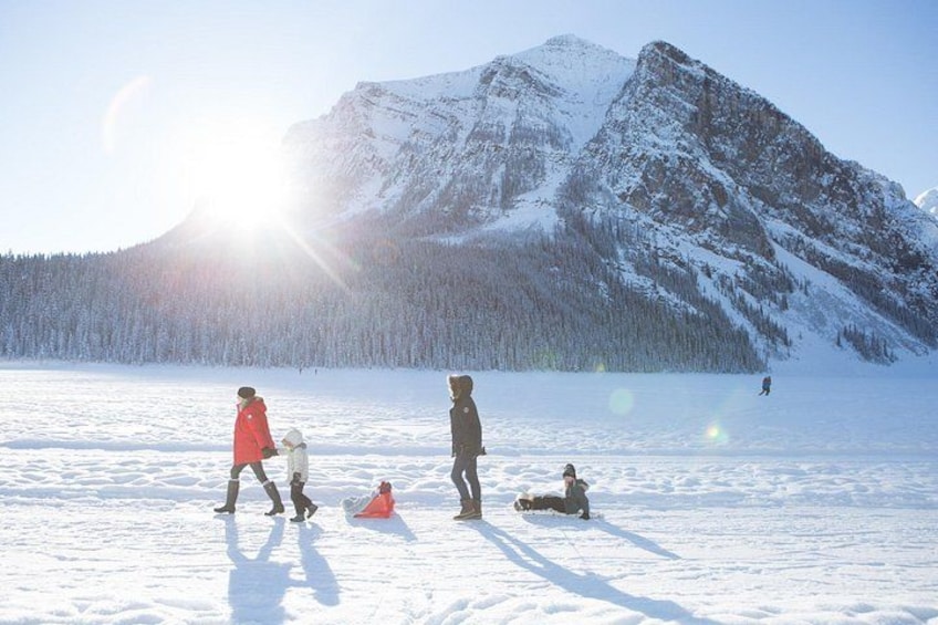 Un paysage enneigé avec une montagne en arrière-plan et des personnes pratiquant des activités hivernales. 3