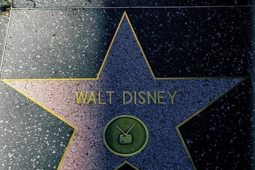 En stjerne på Hollywood Walk of Fame med navnet 'WALT DISNEY' og et ur. 4