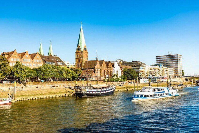 Une rivière où l’on peut voir des bateaux, des bâtiments historiques et le clocher d’une église. 3