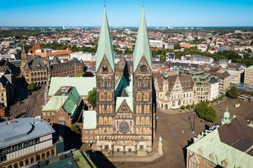 Un duomo con due slanciate guglie, circondato da un panorama urbano con diversi edifici. 3