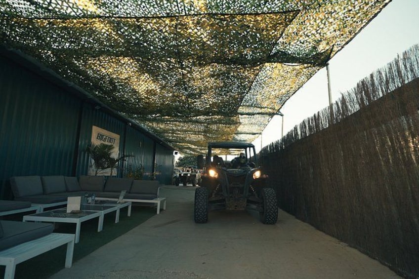 A covered outdoor area with seating, a vehicle, and a fence. 3