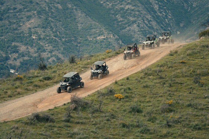 Off-road vehicles on a dirt road in a hilly area. 4