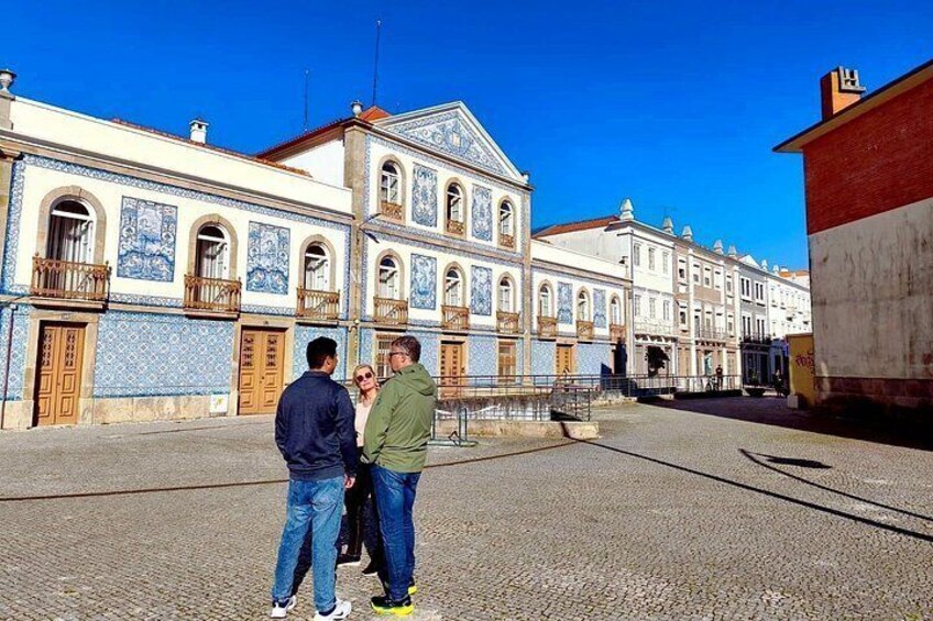 A historic building with blue and white tiles, a cobblestone street, and a clear blue sky. 5