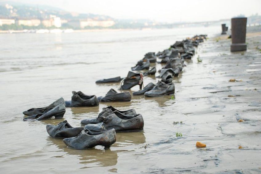 A row of shoes lined up on a riverbank. 4