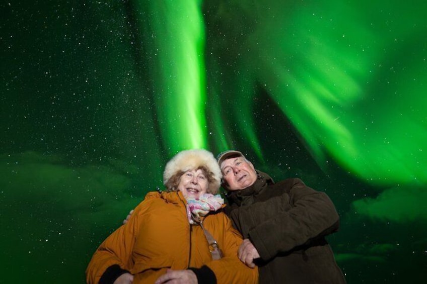 Two people sitting under the aurora borealis. 5