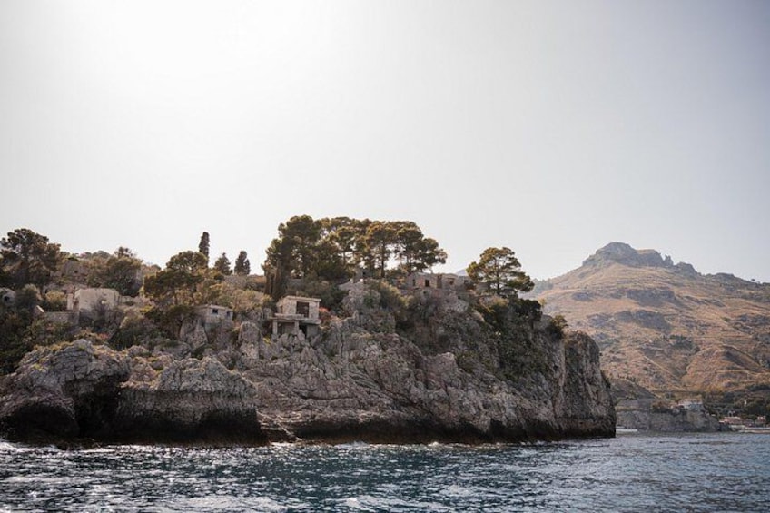 A rocky island with ancient ruins and trees. 2