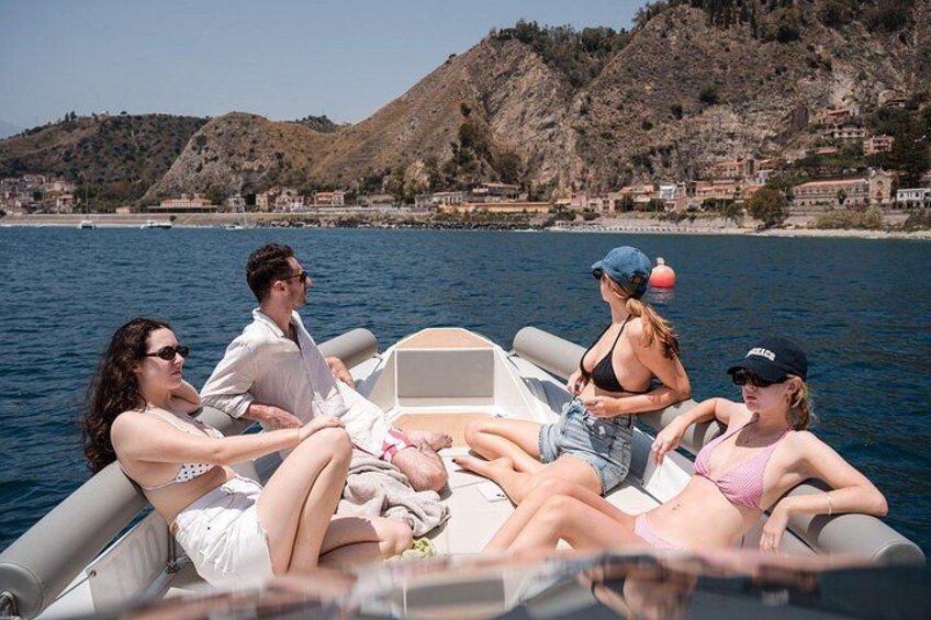 A group of people on a boat with a mountainous landscape in the background. 3