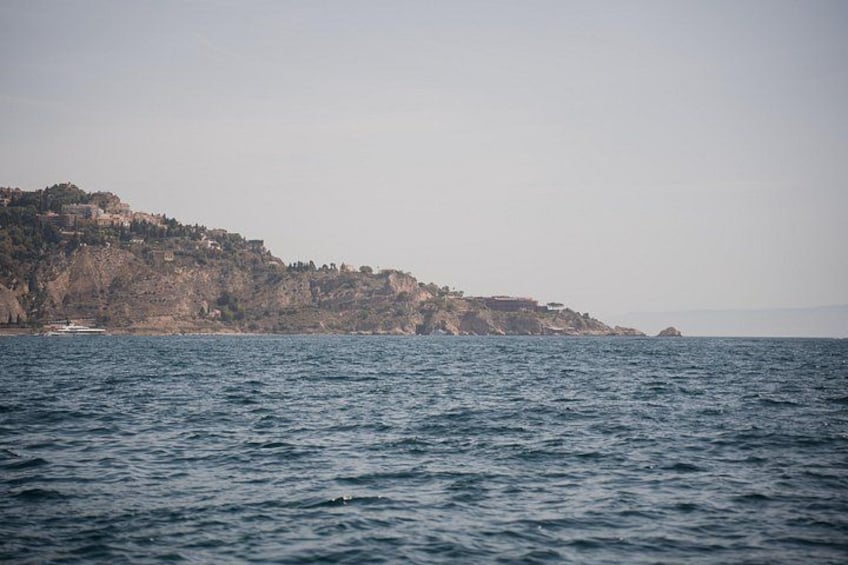 A coastal landscape with a rocky cliff and a body of water. 4