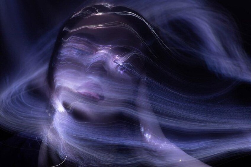A blurred, abstract depiction of a face with flowing lines and light effects. 2