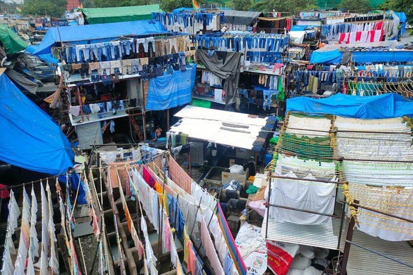 Een levendige openbare markt met diverse kraampjes die kleding en textiel aanbieden. 5