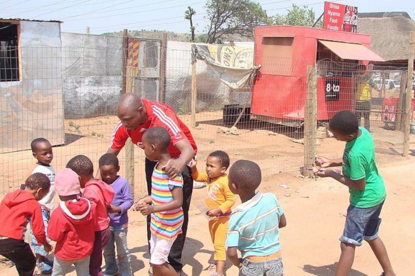 Children playing outdoors with an adult. 1