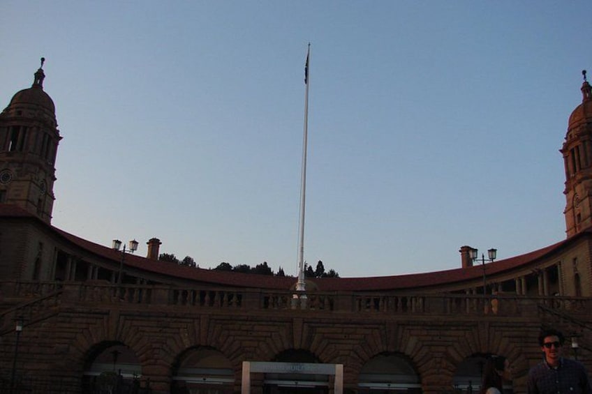 A large building with a central flagpole, arched windows, and two towers. 3