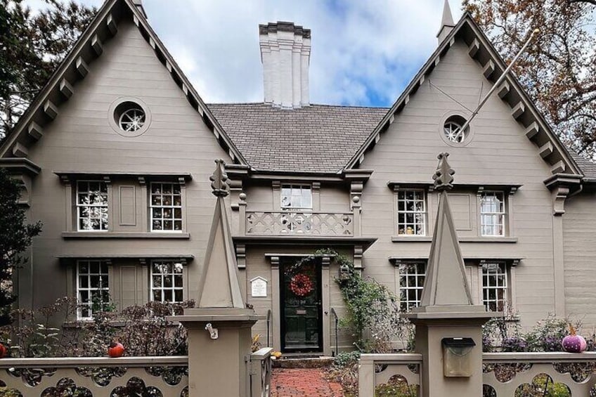 A two-story house with a symmetrical facade, a central entrance with a wreath, and a small circular window above the door. 5