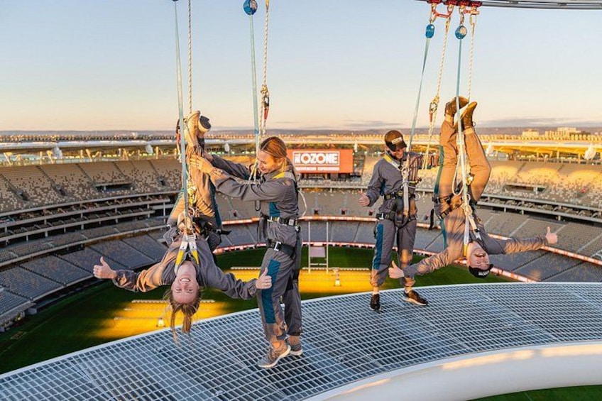 A stadium with a suspended platform and people performing acrobatics. 3