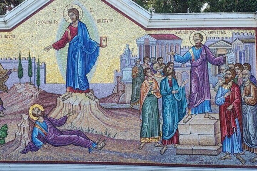 A mosaic with a central figure in blue robes, surrounded by other figures in various colors, set against a backdrop of classical architecture. 5