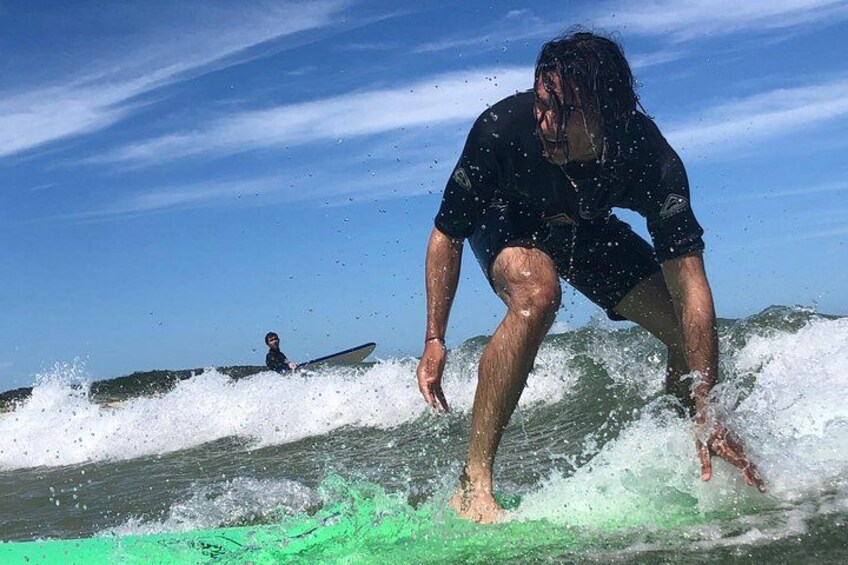 A surfer riding a wave on a green surfboard. 2