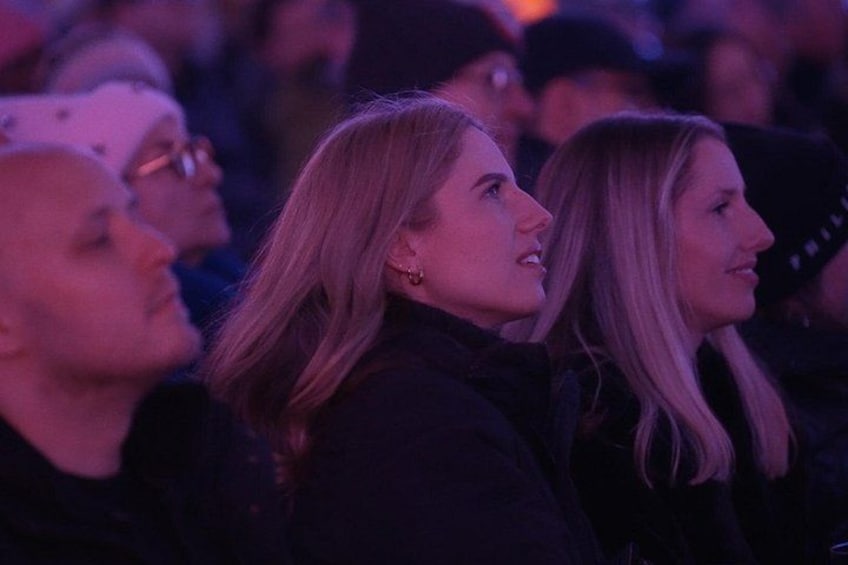 Un grupo de personas en un espacio interior tenuemente iluminado. 2