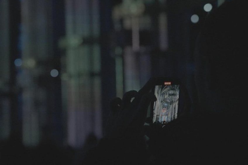 A person holding a smartphone with a dark screen, possibly displaying an image or video. 5