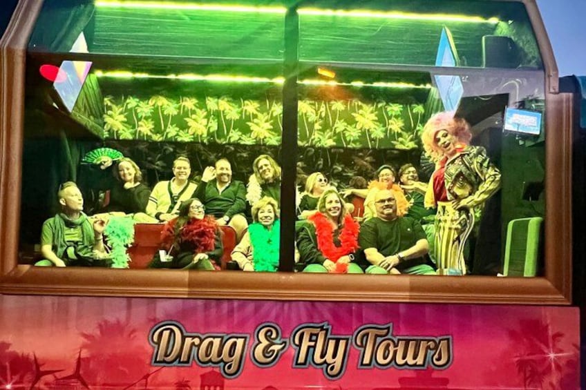 Eine Gruppe von Personen in einem Fahrzeug mit einem 'Drag & Fly Tours'-Schild. 2