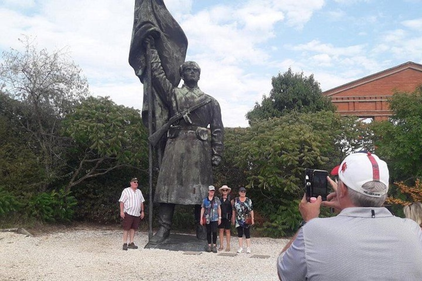 En statue af en historisk person med en gruppe mennesker foran. 1