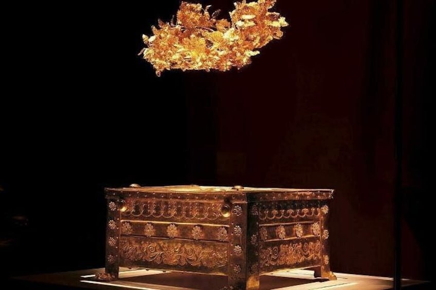 An ornate wooden chest with intricate carvings, displayed under a chandelier. 2