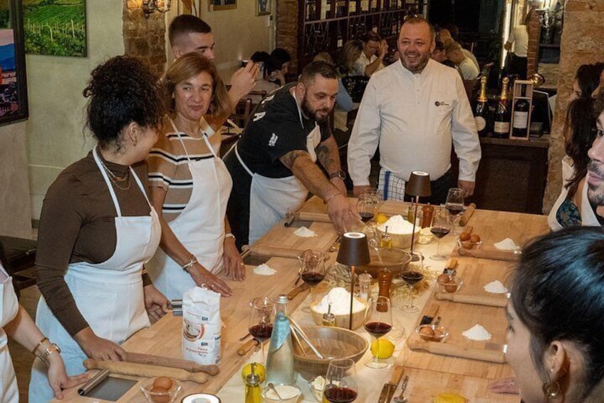 Un gruppo di persone prepara cibo a un tavolo di legno in un ristorante. 2