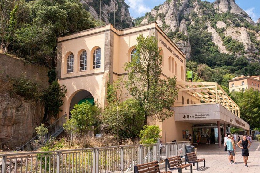 Un bâtiment doté de fenêtres en arc de cercle et d’une enseigne indiquant « FUNICULAIRE DE LA MONTANA ». 3