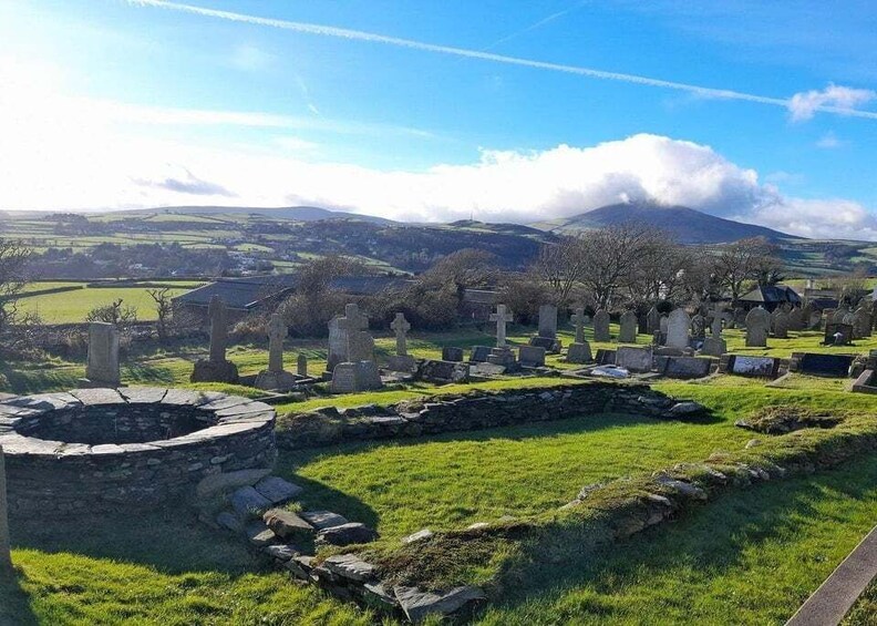 A cemetery with stone crosses and a circular stone structure. 1