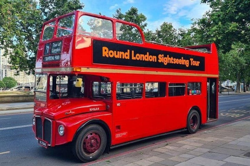 A red double-decker bus with 'Round London Sightseeing Tour' written on the side. 2
