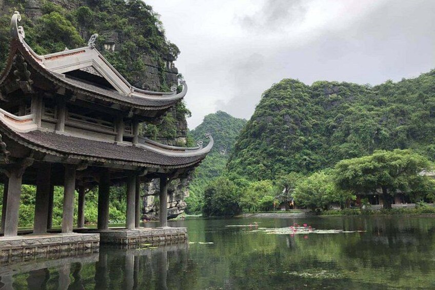 A traditional Chinese pavilion by a calm lake surrounded by lush greenery. 2