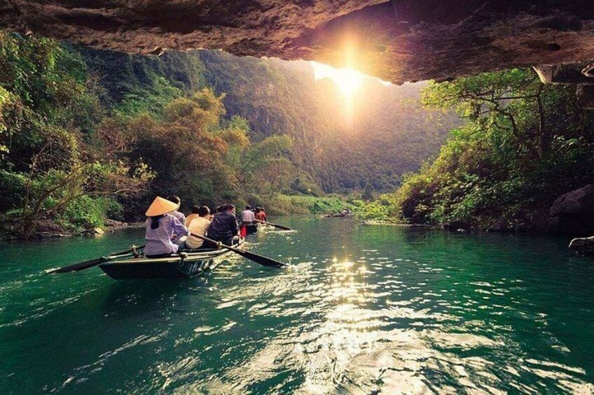 A group of people rowing a boat on a river surrounded by lush greenery. 4