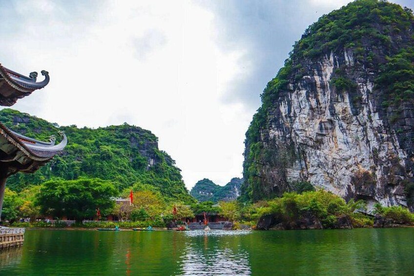 A traditional Chinese pavilion by a calm river with lush greenery and rocky cliffs. 3