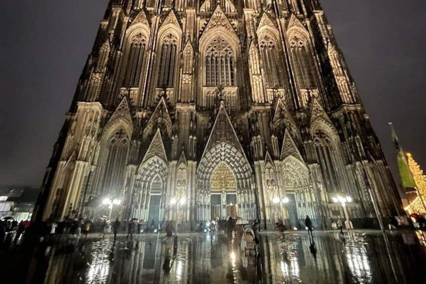 A large cathedral with intricate Gothic architecture, illuminated by lights at night. 2