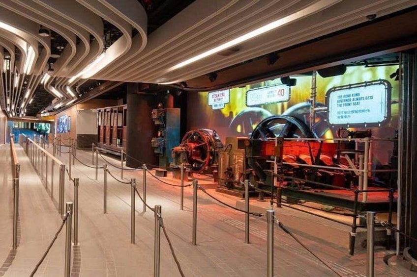 A museum interior with a red car exhibit, glass display cases, and a curved ceiling. 2