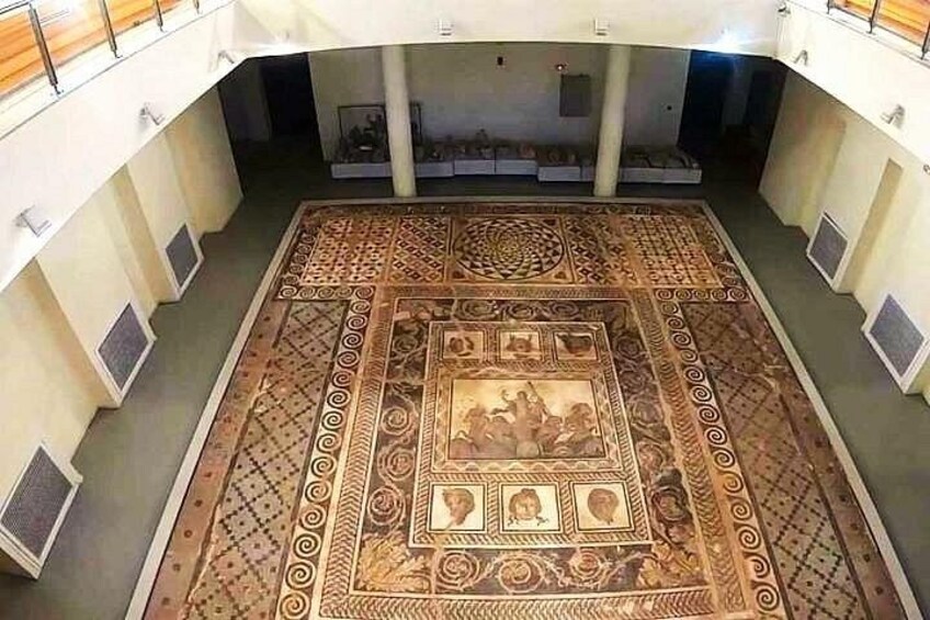 Un ampio pavimento a mosaico, ricco di decorazioni, in un edificio con soffitto alto e colonne. 2
