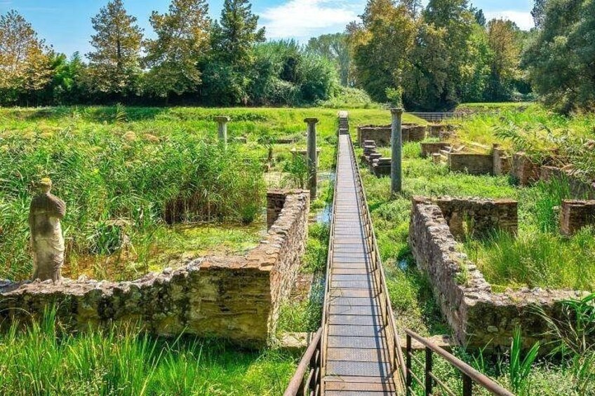 Un ponte di legno sopra un canale d'acqua, circondato da muri di pietra e vegetazione. 5