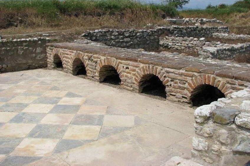 Rovine antiche con archi in pietra e pavimento a scacchi. 3