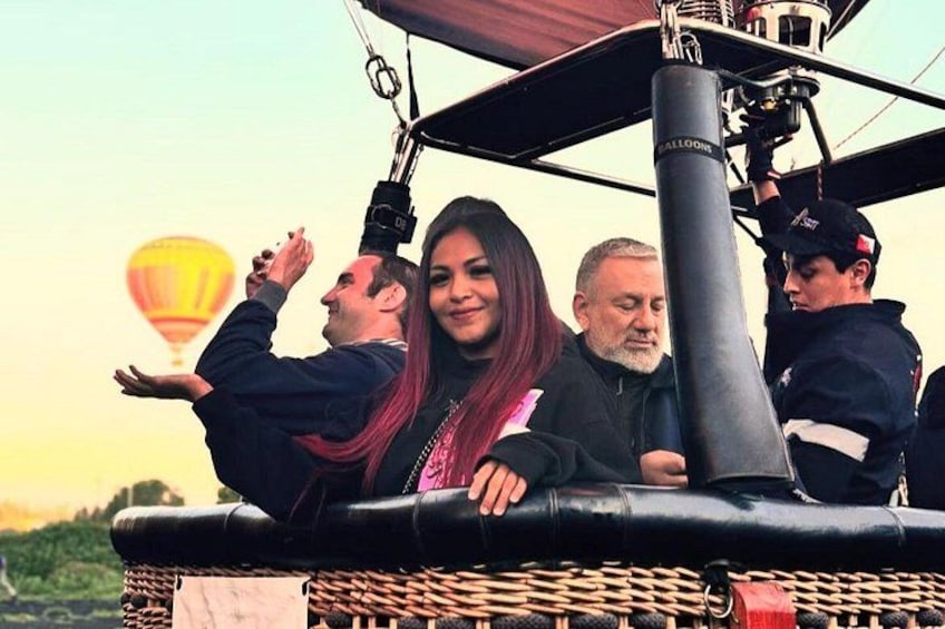 Un globo aerostático con pasajeros, una canasta de mimbre y otro globo aerostático al fondo. 1
