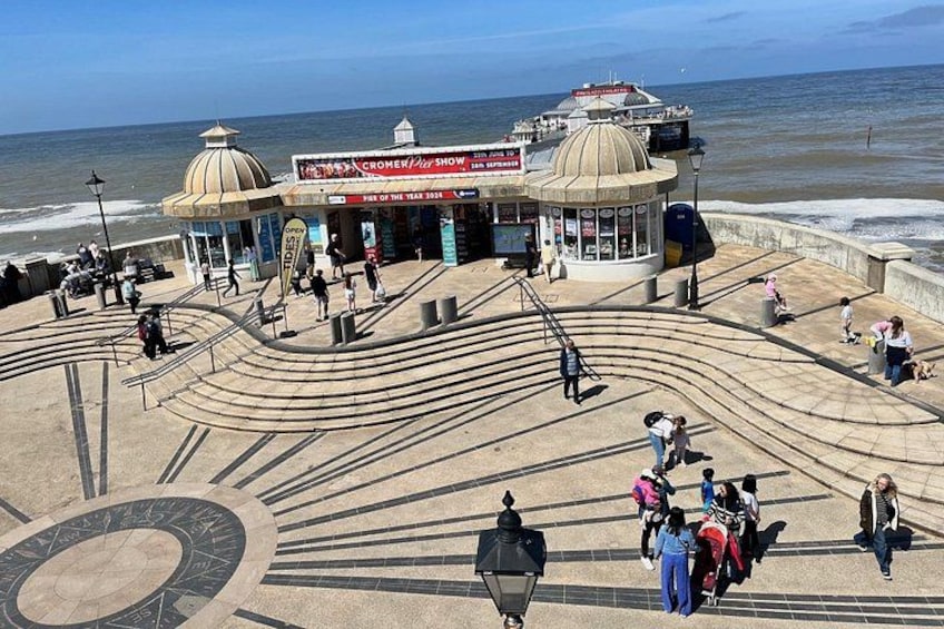 A coastal promenade with a dome-shaped building, a curved walkway, and the ocean in the background. 3