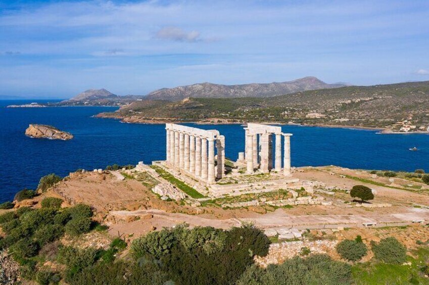 Admire the breathtaking view of the Temple of Poseidon, majestically perched on Cape Sounion's cliffs. The expansive Aegean Sea creates the perfect backdrop for a memorable experience. 1