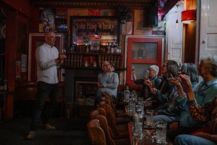 A bar with patrons seated and a bartender standing. 4