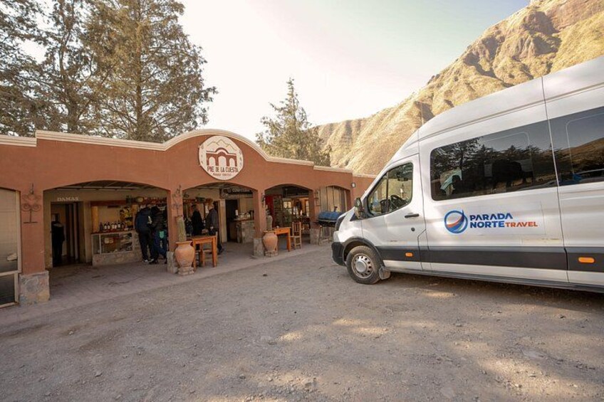 Una camioneta blanca estacionada frente a un edificio con un letrero que dice 'PARADA NORTE TRAVEL'. 2