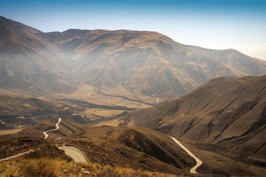 A winding mountain road through a rugged, hilly landscape. 3