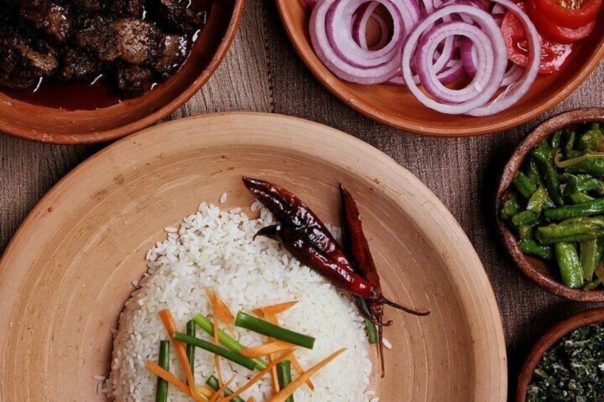 A wooden plate with white rice, green beans, and red chili peppers. 1