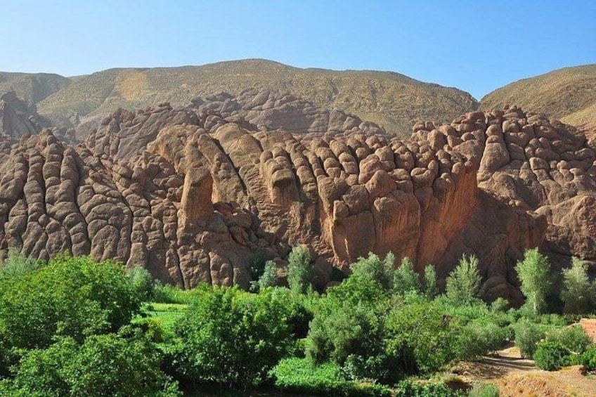 A desert landscape with prominent rock formations and sparse vegetation. 2