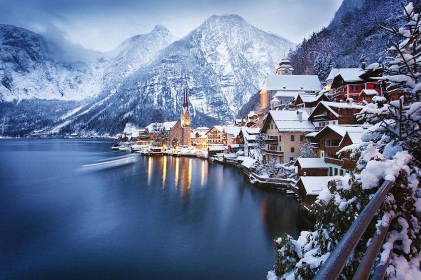 A snow-covered village by a calm lake with mountains in the background. 4