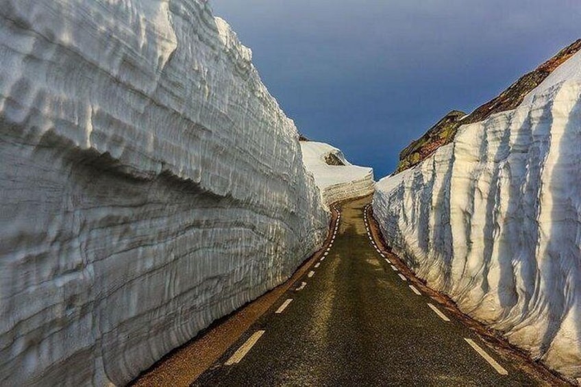 A road flanked by snow-covered cliffs. 4
