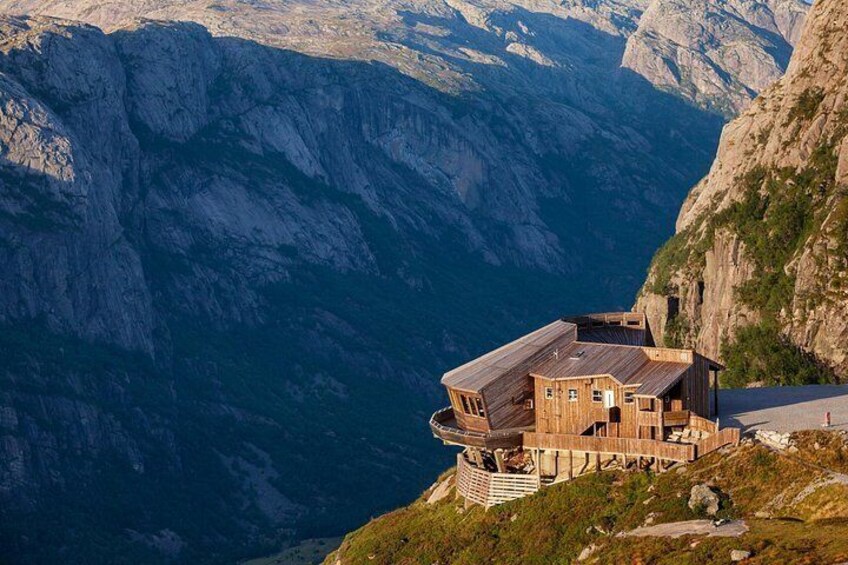 A wooden house built into a cliffside overlooking a deep canyon. 2
