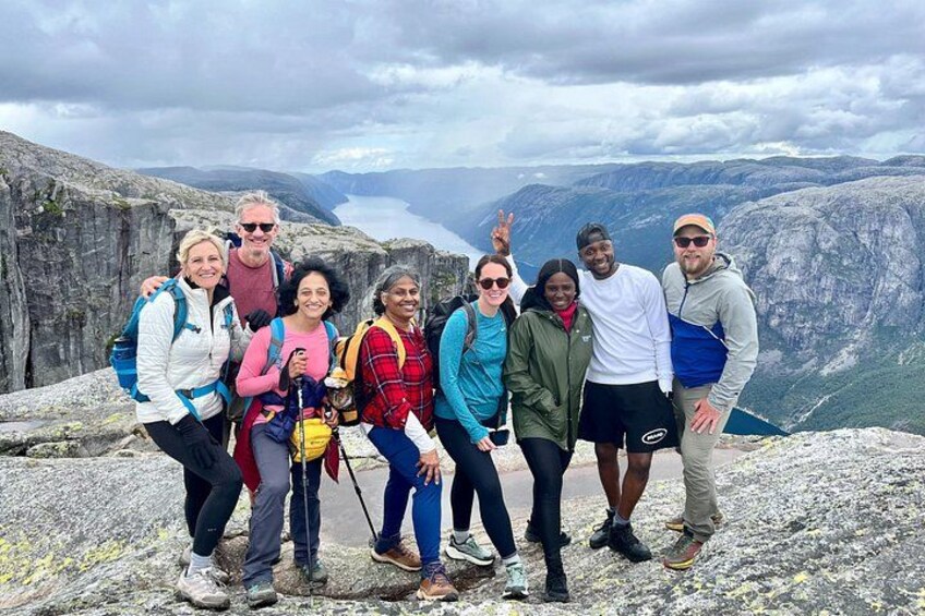 A group of people on a rocky mountain peak with a lake in the background. 3