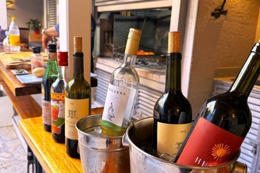 A variety of wine bottles in a bucket on a wooden table. 4